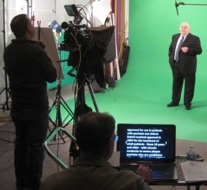 Teleprompter operator, cameraman and talent on the green scree video production set.
